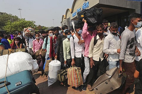 People wearing masks as a precaution against the coronavirus stand in queues to board trains at Lokmanya Tilak Terminus in Mumbai. (Photo | AP)