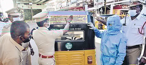 Deputy Commissioner of Police, Traffic, (Chennai East), Balakrishnan pasting a Covid awareness sticker on an auto at Purasaivakkam, in Chennai | P Jawahar