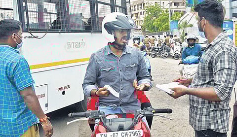 Chennai Corporation staff collecting fine from a person for not wearing mask on Velachery High Road on Thursday | Ashwin prasath