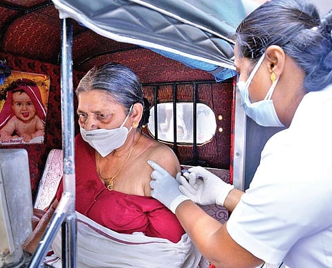 A health worker administers the first dose of vaccine to an elderly woman in an autorickshaw stationed outside Govt LP school, Kariyam, T’Puram | Vincent Pulickal