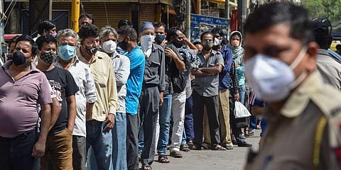 People stand in a queue to buy alcohol from a wine shop after Delhi Government announced complete lockdown for 6 days due to surge in coronavirus cases, in New Delhi. (Photo | PTI)