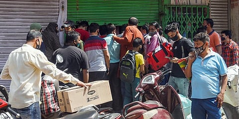 People rush to ration shops to buy essential things after the Delhi government imposes a one-week curfew. (Photo| ANI)