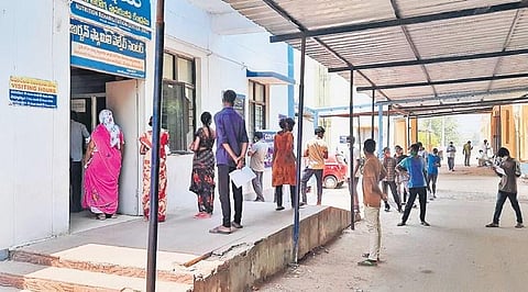 People wait outside the MGM Hospital in Warangal to get tested for Covid