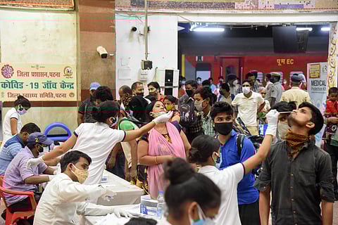Health workers collect swab samples of the passengers arriving from Maharashtra at a COVID-19 testing counter on Sunday at Patna railway station. (Photo | PTI)