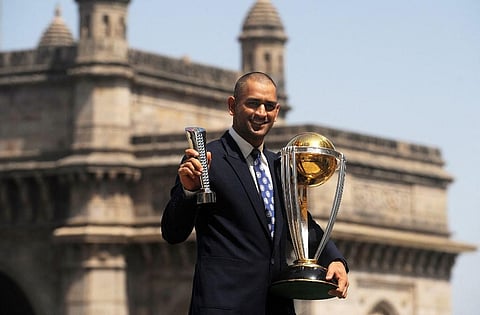 Mahendra Singh Dhoni poses with the Man of the match and the ICC Cricket World Cup trophy near the Gateway of India. (Photo | AFP)