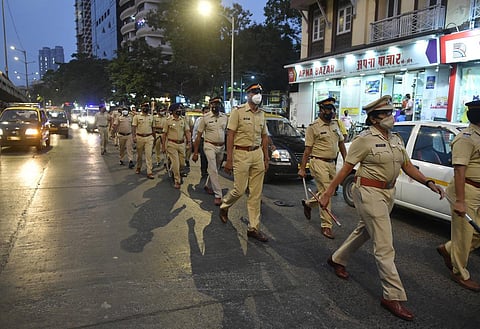 Police personnel conduct a flag march during night curfew, imposed by the authorities to curb the spread of coronavirus, in Mumbai. (File photo | PTI)