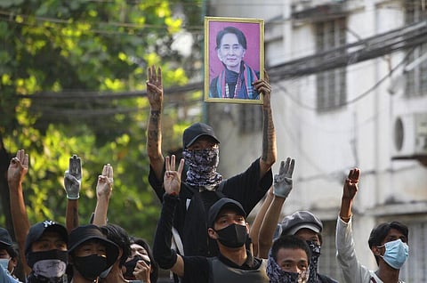 Anti-coup demonstrators raise the three finger of resistance and a portrait of deposed leader Aung San Suu Kyi during a protest. (Photo | AP)