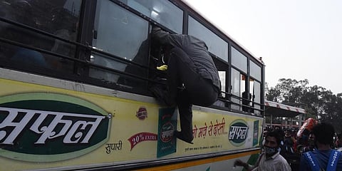 A migrant worker tries to board bus to his native place , after lockdown announcement in New Delhi. (Photo | Parveen Negi, EPS)