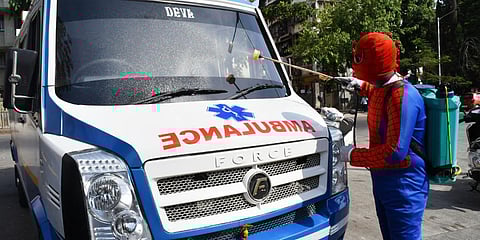 A man, dressed up as Spiderman, sprays disinfectant to an ambulance in Mumbai. (Photo| ANI)