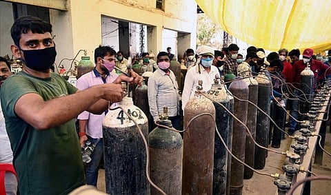 Family members of COVID 19 patient in queue to take cylinder filled with medical oxygen at a plant as coronavirus cases surge across the country, in Prayagraj on Tuesday, April 20, 2021. (Photo | PTI)