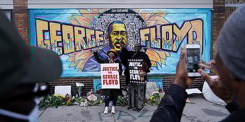 People pose for pictures in front of a mural for George Floyd after a guilty verdict was announced at the trial of former Minneapolis police Officer Derek Chauvin. (Photo | AP)
