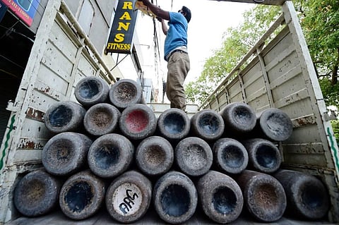 Workers load empty cylinders of medical oxygen, required for treatment of critical COVID-19 patients, as coronavirus cases surge across the country, in New Delhi. (Photo | PTI)