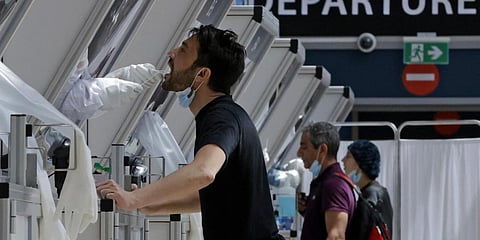 A medic collects a swab sample from a traveller at a rapid COVID-19 testing booth in Israel's Ben Gurion Airport, near Tel Aviv. (File photo| AFP)