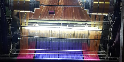A weaver producing a saree on a powerloom. 
