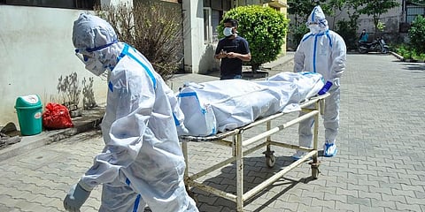 Healthcare workers carrying the body of a COVID victim (Photo | PTI)