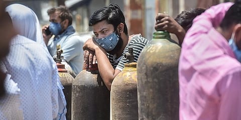 Family members of COVID-19 patients wait to fill their empty cylinders with medical oxygen in Kanpur. (Photo | PTI)