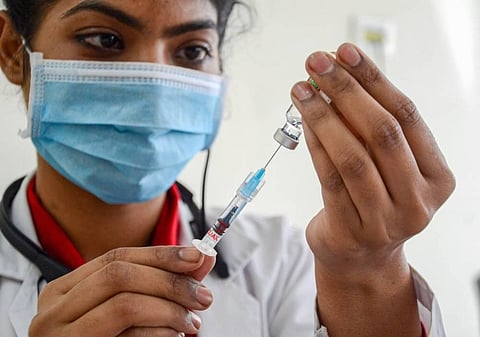 A medical worker prepares to inoculate a person with a dose of COVID vaccine (Photo | PTI)