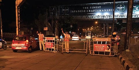Police personnel set up road barricades on the Outer Ring Road in Nagarbhavi, Bengaluru, on Tuesday evening | Vinod Kunar T