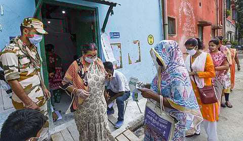 Voters stand in a queue outside a polling station to cast their votes during the last phase of West Bengal Assembly Elections, in Kolkata on Thursday. (Photo | PTI)