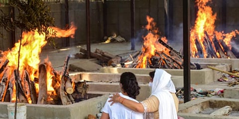 Relatives of a person who died of COVID-19 react at the Sarai Kale Khan crematorium, amid rise in COVID-19 cases across the country, in New Delhi. (Photo | PTI)
