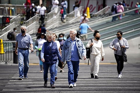 Masked and unmasked pedestrians walk across Las Vegas Boulevard in the US. (Photo | AP)