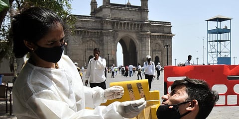 A healthcare worker collects a nasal sample from a man for COVID-19 testing, amid the rise in cases, in Mumbai. (Photo| ANI)
