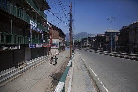 Kashmiri boys ride on their bicycles on a deserted road during lockdown to prevent the spread coronavirus in Srinagar. (Photo | AP)
