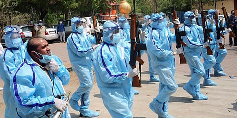 Police personnel protected in PPE kits pay homage to a police inspector who died due to COVID-19 during his last rites in Bhopal. (Photo| ANI)