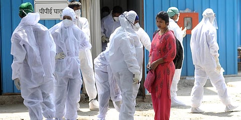 Healthcare workers wear COVID-19 safety kits prior to start their shifts at Jumbo Covid Centre, in Mumbai. (Photo| ANI)