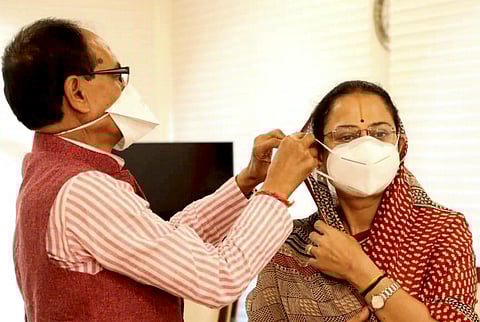 MP CM adjust wife Sadhna's face mask during an awareness campaign in Bhopal. (Photo | PTI)