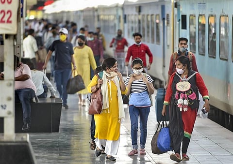 Passengers, wearing masks as per COVID-19 guidelines, arrive at the Charbagh Railway Station amid countrywide spike in the coronavirus cases. (Photo | PTI)