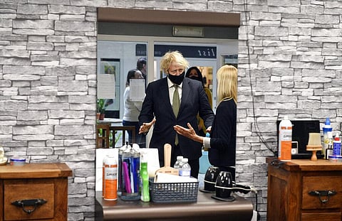 UK Prime Minister Boris Johnson in Lemonheads Barber shop during a visit to Lemon Street Market in Truro, England, Wednesday, April 7, 2021. (Photo | AP)