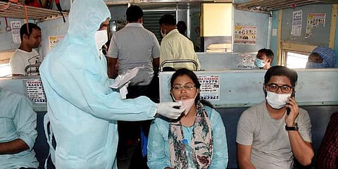 A health worker takes a nasal sample of a passenger inside a train at Patna junction in Patna. (Photo | ANI)