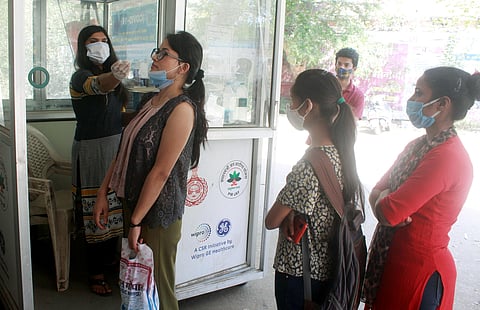 A health worker collects swab samples of residents for COVID-19 tests, amid surge in coronavirus cases, in Gurugram, Friday. (Photo | PTI)
