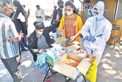 Health workers collect samples from passengers and commuters near KSRTC Bus Stand in Bengaluru. (Photo | Vinod Kumar T, EPS)
