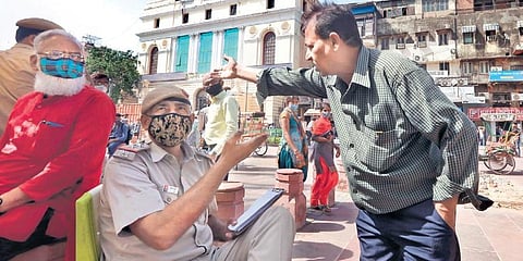 Delhi Police personnel issues a challan to a man for not wearing face mask in New Delhi on Thursday. (Photo | Shekhar Yadav, EPS)