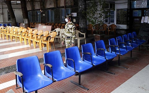 A security officer stands at a vaccination center, deserted due to the shortage of COVID-19 vaccine, in Mumbai. (Photo | AP)