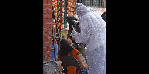 A health worker takes a swab sample of a woman for an  RT-PCR test, in Bengaluru on  Thursday. (Photo | Vinod Kumar T, EPS)