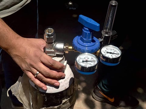 A family member wait to refill oxygen cylinders for COVID-19 patients at a oxygen filling centre, in New Delhi, Sunday, May 9, 2021. (Photo | PTI)