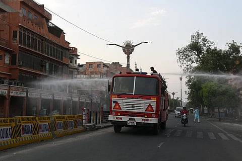 Fire Fighters sprays disinfection at Johri Bazar area during corona curfew, in Jaipur on Sunday. (Photo | ANI)