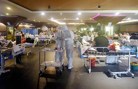 Health workers check COVID-19 patients receiving treatment inside a banquet hall, covered into a COVID-19 isolation centre, in New Delhi. (File Photo | PTI)