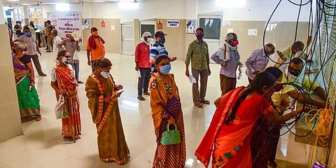 Beneficiares stand in a queue to take COVID-19 vaccine dose, at a vaccination centre in Varanasi. (Photo | PTI)