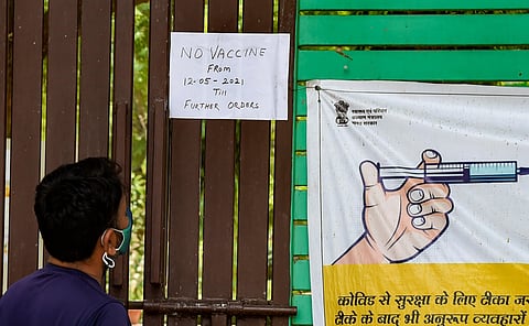 A man looks at a notice stating non-availability of vaccines, outside a vaccination centre in New Delhi, Wednesday, May 12, 2021. (Photo | PTI)