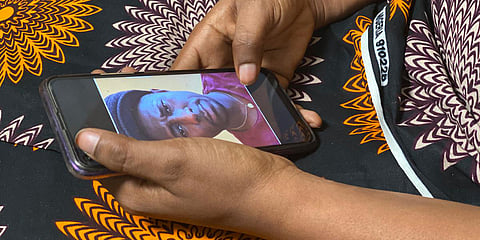 A woman holds her phone displaying a photo of former World Health Organization doctor Boubacar Diallo, of Canada, during an interview in the eastern Congo town of Goma. (Photo| AP)