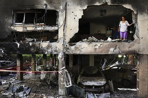 Members of Sror family inspect the damage of their apartment after it was hit by a rocket fired from the Gaza Strip over night in Petah Tikva, central Israel, Thursday, May 13, 2021. (Photo | AP)