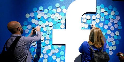 Attendees stick notes on a Facebook logo at F8, the Facebook's developer conference. (Photo | AP)