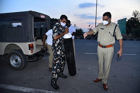 Kurnool SP Fakeerappa Kaginelli arranges an oxygen cylinder to a patient whose ambulance was stopped at Pullur toll plaza on Friday. (Photo | EPS)
