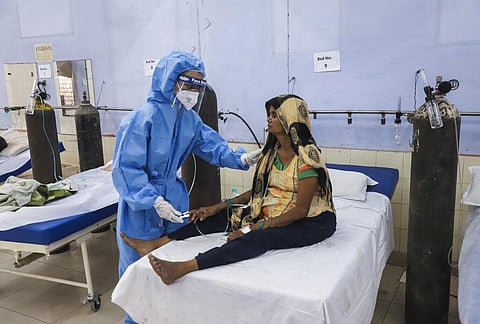 A nurse attends to a patient at a free COVID-19 care center being operated by a Sikh voluntary organization in Ghaziabad. (Photo | AP)