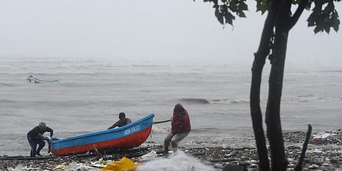 Fishermen pull their boat ashore to a safe place during formation of cyclone Tauktae in Mumbai. (Photo| PTI)