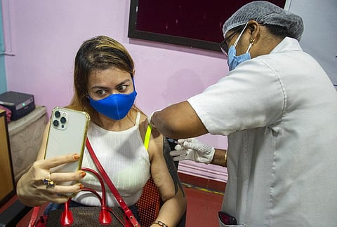 A woman takes selfie as she receives the Covishield vaccine against COVID-19 in Gauhati, Assam. (Photo | AP)